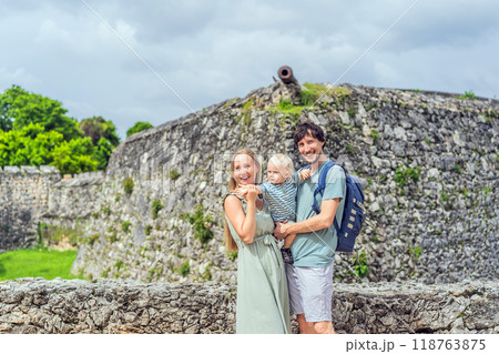 Mom, dad and their baby son exploring Fuerte de San Felipe de Bacalar. Family travel, cultural heritage, and historical adventure concept 118763875