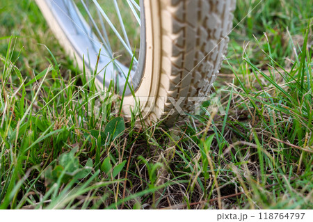 Bicycle wheel with white color tire on the grass Bicycle wheel with white color tire on the grass 118764797