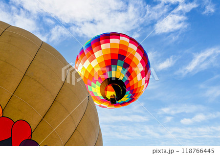 Colorful hot air balloon flying over blue sky with white clouds Colorful hot air balloon flying over blue sky with white clouds 118766445