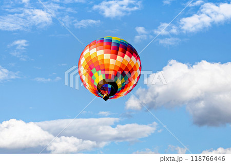 Colorful hot air balloon flying over blue sky with white clouds Colorful hot air balloon flying over blue sky with white clouds 118766446