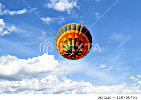 Colorful hot air balloon flying over blue sky with white clouds	 118766458