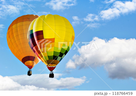 Colorful hot air balloon flying over blue sky with white clouds	 118766459