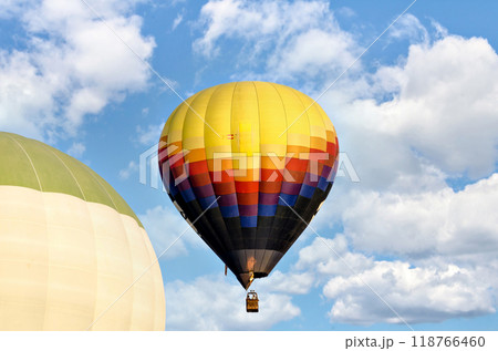 Colorful hot air balloon flying over blue sky with white clouds	 118766460