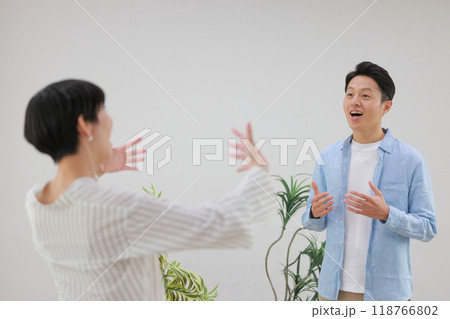 ボーカルトレーニングする男性と大きな身振りで指示するトレーナー女性_1 118766802