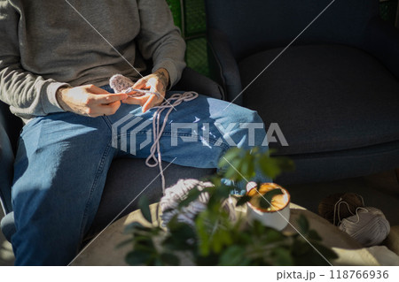 Hipster feminine male crochet handmade knitting hobby with colored yarn and hook at wooden interior Hipster feminine male crochet handmade knitting hobby with colored yarn and hook at wooden interior 118766936