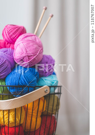 Lots of bright, colorful yarns for knitting and crochet in a stylish scandi style basket.  118767007