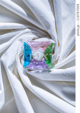 Washing gel capsule pods with laundry detergent on a pile of white cloth background 118767009