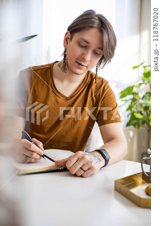 Stylish confident guy writing in journal Stylish confident guy writing in journal 118767020