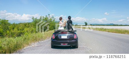 愛車とフォトウェディングを撮る新郎新婦(オープンカー) 愛車とフォトウェディングを撮る新郎新婦(オープンカー) 118768251