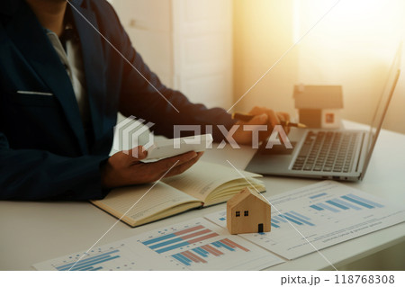 Businessmen holding pens, signing home titles with insurance, care about real estate services and the idea of real estate agents offering interest in installments to their customers. 118768308