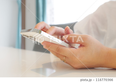 スマホを操作する女性（顔なし） 118770366