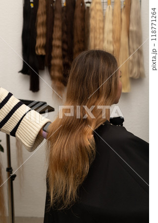 The hairdresser holds the strands of the client's hair in his hands. Barbershop 118771264