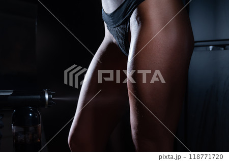 The master applies tinting paint to the woman's legs. Instant tanning procedure The master applies tinting paint to the woman's legs. Instant tanning procedure 118771720
