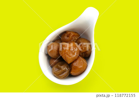 Pickled plums on green background. 118772155