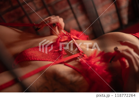 Close-up of belly of woman in erotic red lingerie lying on bed. Close-up of belly of woman in erotic red lingerie lying on bed. 118772264