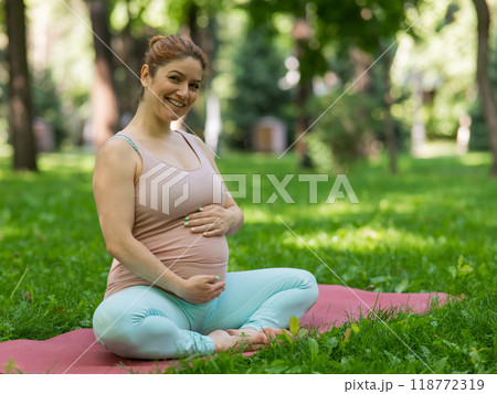 Prenatal yoga. Caucasian pregnant woman doing butterfly pose in the park. Prenatal yoga. Caucasian pregnant woman doing butterfly pose in the park. 118772319