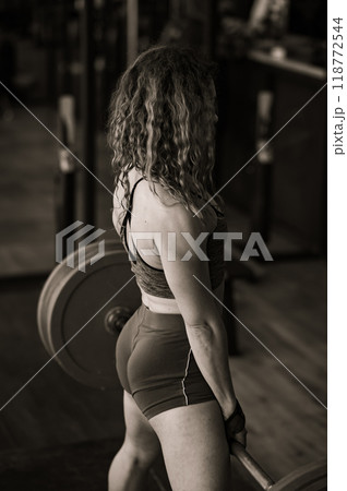 Middle aged woman doing deadlifts in the gym.  118772544