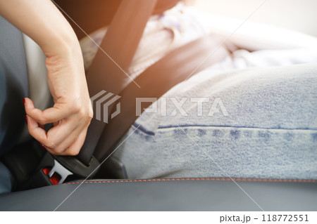 Close Up of people business woman hand fastening seat safety belt in car for safety before driving on the road. concept transport travel. soft focus. 118772551