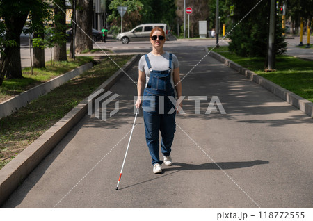 Blind pregnant woman walking down the street with a cane. Blind pregnant woman walking down the street with a cane. 118772555