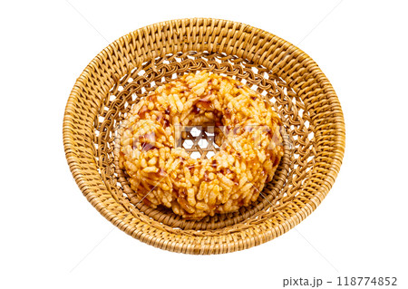 High angle view of single homemade crispy rice cracker in bamboo basket. High angle view of single homemade crispy rice cracker in bamboo basket. 118774852