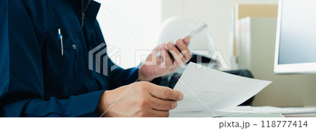 書類をチェックする作業服の男性 書類をチェックする作業服の男性 118777414