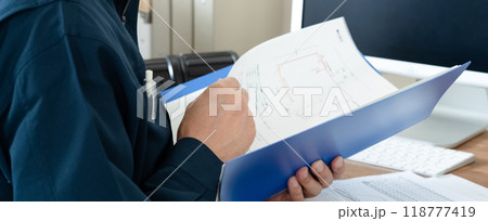 書類をチェックする作業服の男性 書類をチェックする作業服の男性 118777419