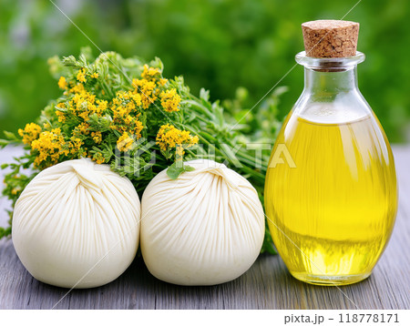 Herbal compress balls with fresh yellow flowers and a glass bottle of aromatic oil Herbal compress balls with fresh yellow flowers and a glass bottle of aromatic oil 118778171