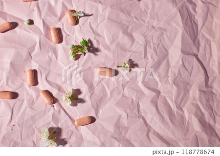 Overhead View of Multiple Blister Packs of Medication on a Crumpled Pink Surface 118778674