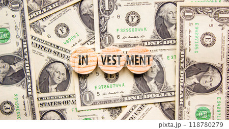 Investment symbol. Concept word Investment on beautiful wooden circles. Dollar bills. Beautiful background from dollar bills. Business investment concept. Copy space. Investment symbol. Concept word Investment on beautiful wooden circles. Dollar bills. Beautiful background from dollar bills. Business investment concept. Copy space. 118780279