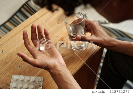 Male hands with pill and glass of water 118781275