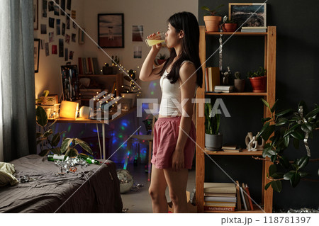 Taking dissolved pill in messy room 118781397