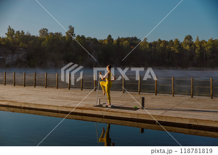 A Morning Runner Enjoys a Peaceful Run by the Serene Lake Surrounded by Scenic Landscape A Morning Runner Enjoys a Peaceful Run by the Serene Lake Surrounded by Scenic Landscape 118781819