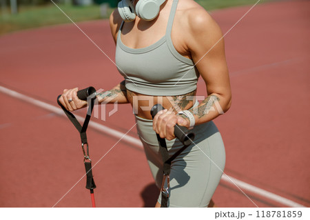 Athletic Woman Engaging in Intensive Training with Resistance Bands on a Track Surface 118781859