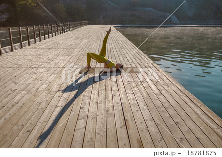 Experience a Serene Yoga Practice on a Peaceful Dock by the Water Surrounded by Nature Experience a Serene Yoga Practice on a Peaceful Dock by the Water Surrounded by Nature 118781875