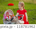 little girl plays with a doll and a stroller 118781962