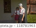 Woman and girl standing in front of building, smiling happily 118781963