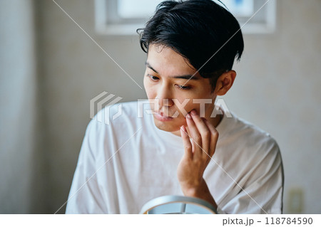 肌を気にする20代の若い男性 肌を気にする20代の若い男性 118784590
