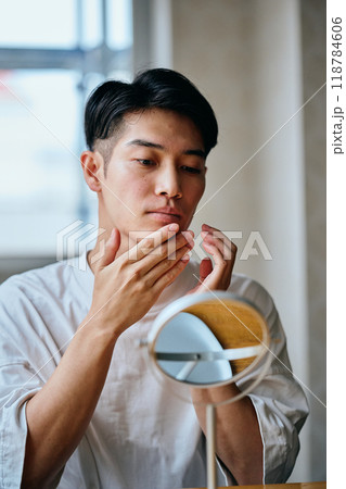 肌を気にする20代の若い男性 肌を気にする20代の若い男性 118784606