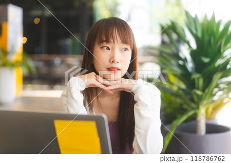 Portrait of young adult asian student woman using laptop at cafe for study and work 118786762