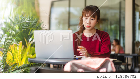 Young adult asian student woman using laptop at cafe for study and work or business Young adult asian student woman using laptop at cafe for study and work or business 118786782