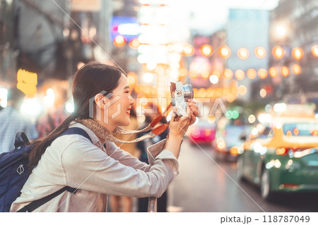 Young adult asian woman traveller backpack using camera photography in city Young adult asian woman traveller backpack using camera photography in city 118787049
