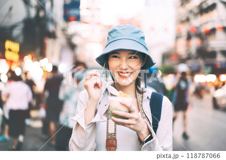 Young adult asian foodie woman backpack traveler eating thai dessert at china town street food. Young adult asian foodie woman backpack traveler eating thai dessert at china town street food. 118787066