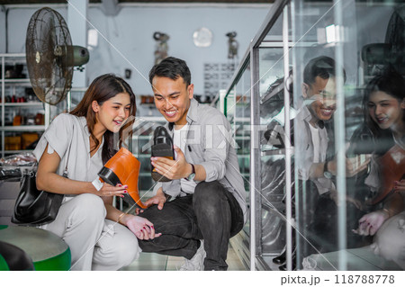 asian couple male holding leather shoes while shopping at store asian couple male holding leather shoes while shopping at store 118788778