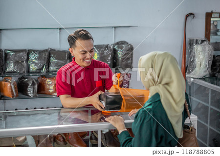 male employee puts purchased product into plastic bag 118788805