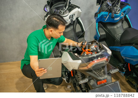professional technician repairing electric motorbike using tablet 118788842