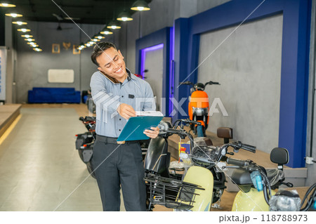 asian worker reviews document speaking phone 118788973