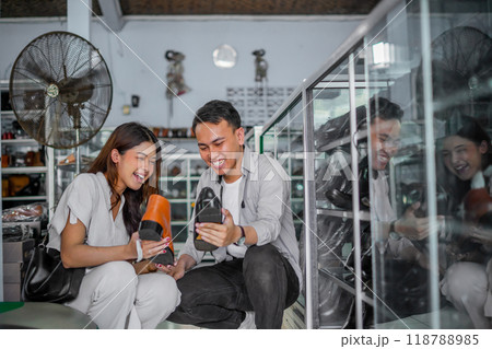 happy couple holding male leather shoes while shopping 118788985
