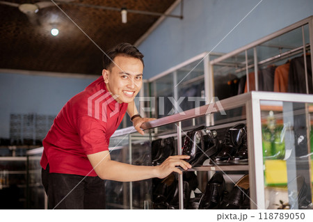 professional salesman organize and arrange black leather shoes on shelves professional salesman organize and arrange black leather shoes on shelves 118789050