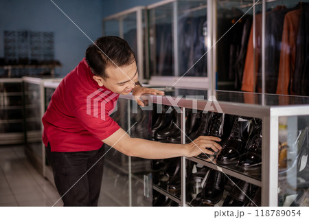 asian employee organize leather shoes and putting into shelves with happy face asian employee organize leather shoes and putting into shelves with happy face 118789054