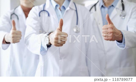 Group of doctors are are standing and showing thumbs up in hospital corridor. Medicine excellent service Group of doctors are are standing and showing thumbs up in hospital corridor. Medicine excellent service 118789077